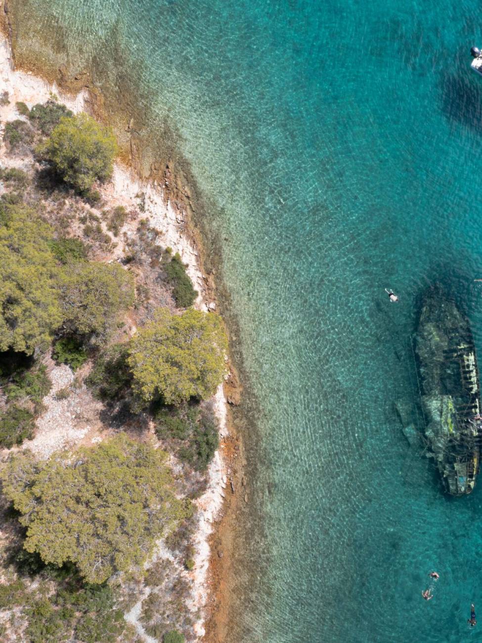 An aerial shot of a shipwreck in the sea on a sunny day in Kontesa, Croatia